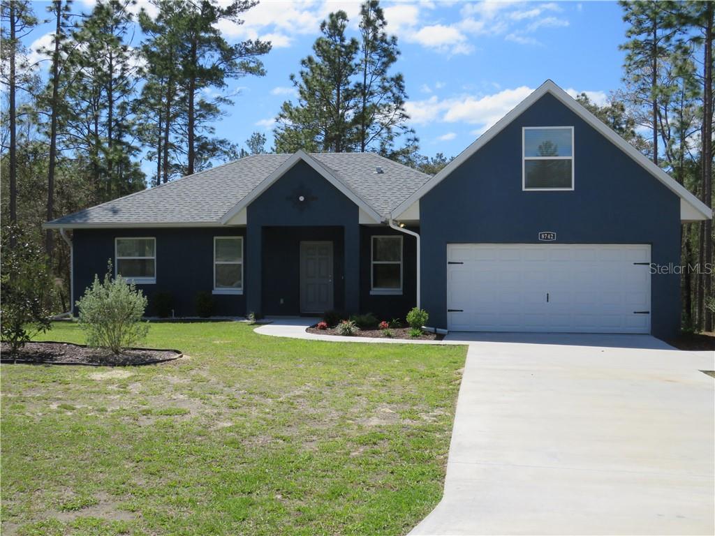 8742 Southwest 135th Street Road Ocala, FL 34473 - Photo 1 of 1 a front view of a house with a yard