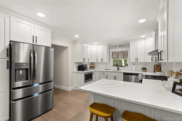 a kitchen with stainless steel appliances a refrigerator sink and stove