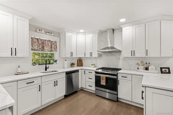 a kitchen with white cabinets stainless steel appliances and sink