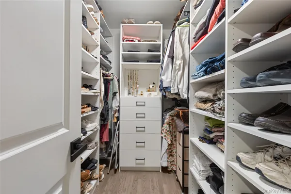 a view of walk in closet with clothes and shoes