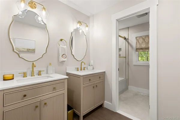 a bathroom with a double vanity sink and a mirror with shower
