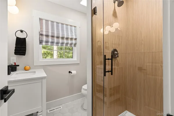 a bathroom with a shower sink and mirror