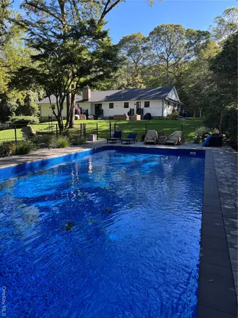 a view of swimming pool and trees in the background