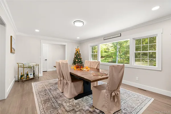 a dining room with furniture window and wooden floor