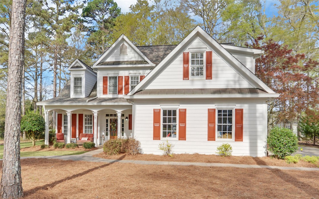 39 Azalea Drive Hartwell, GA 30643 - Photo 2 of 45 This charming home showcases a welcoming front porch, dormer windows, and a classic white exterior.