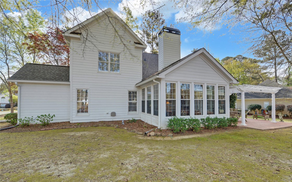 39 Azalea Drive Hartwell, GA 30643 - Photo 42 of 45 This residence features a charming sunroom, a backyard patio with a pergola, and a classic chimney.