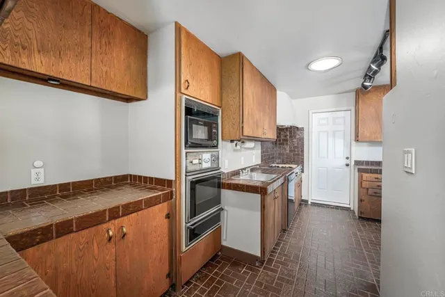 a kitchen with stainless steel appliances granite countertop a stove a sink and a refrigerator