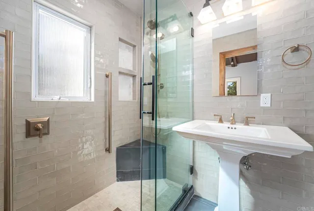 a bathroom with a sink a mirror and a shower