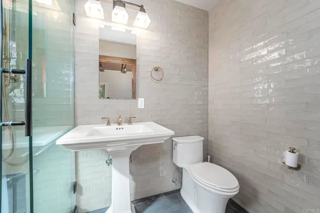 a bathroom with a sink toilet and a mirror