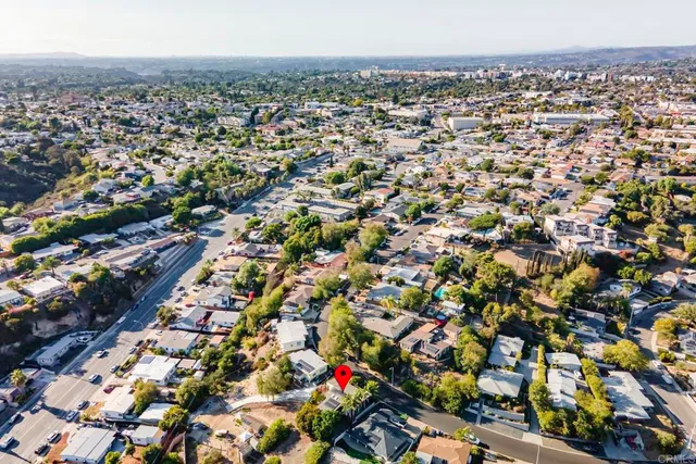 an aerial view of residential houses with outdoor space and trees
