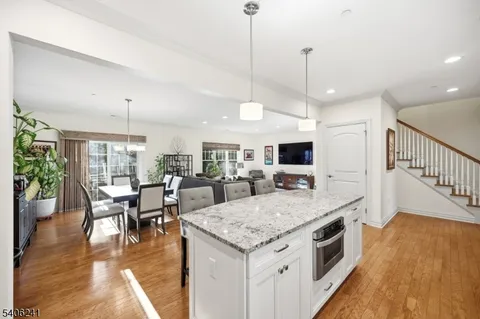 a view of a dining room and livingroom with furniture wooden floor a chandelier