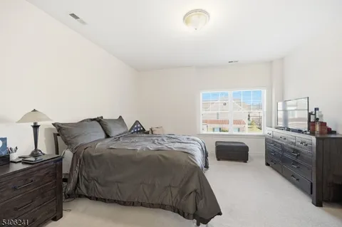 a spacious bedroom with a bed and a dresser