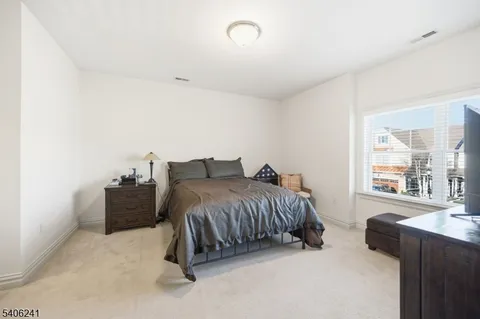 a spacious bedroom with a bed and wooden floor