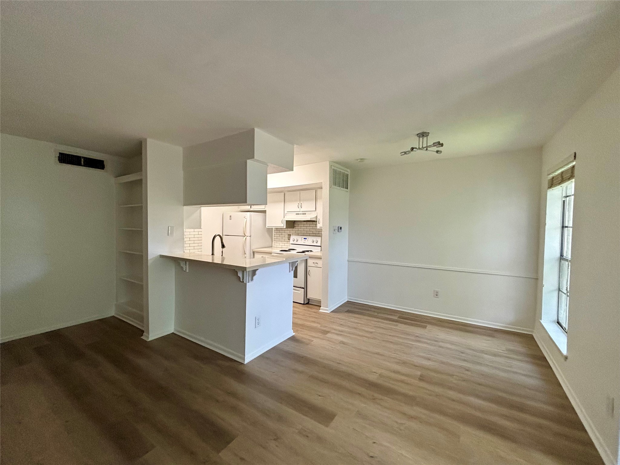 2800 Jeanetta Street, Unit 2008 Houston, TX 77063 - Photo 12 of 22 a room with kitchen island granite countertop wooden floors and white cabinets