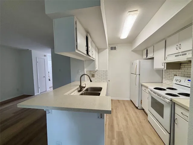 a kitchen with stainless steel appliances a sink stove and refrigerator