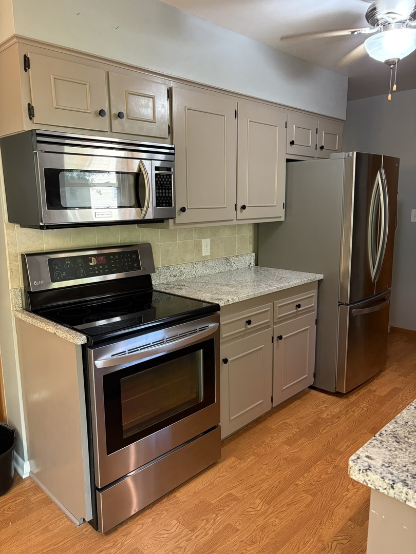 5209 12th Avenue Moline, IL 61265 - Photo 14 of 33 a kitchen with granite countertop a stove microwave and refrigerator
