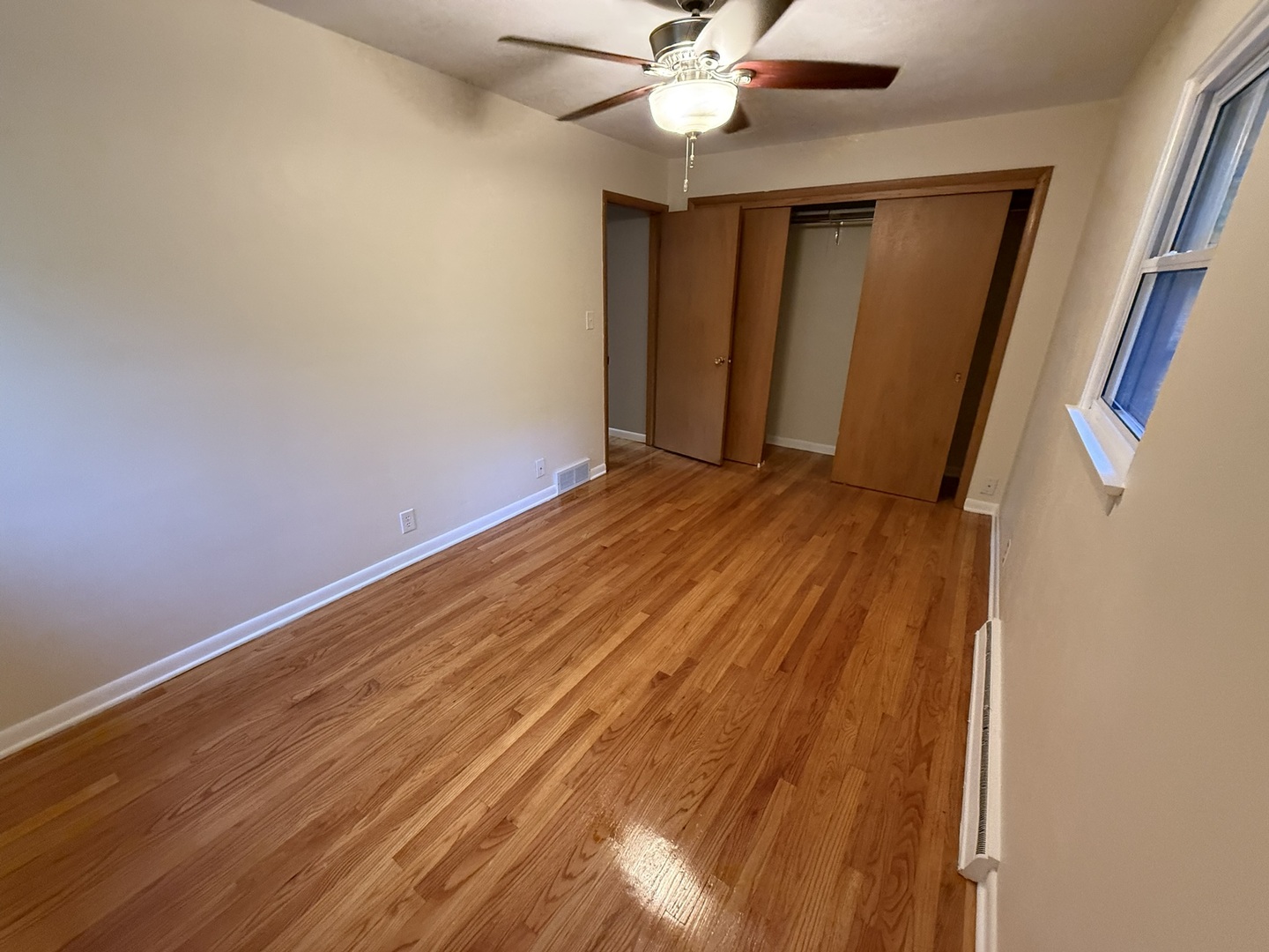 5209 12th Avenue Moline, IL 61265 - Photo 20 of 33 a view of an empty room with wooden floor and a ceiling fan