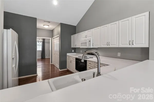 a kitchen with stainless steel appliances kitchen island granite countertop a refrigerator and cabinets