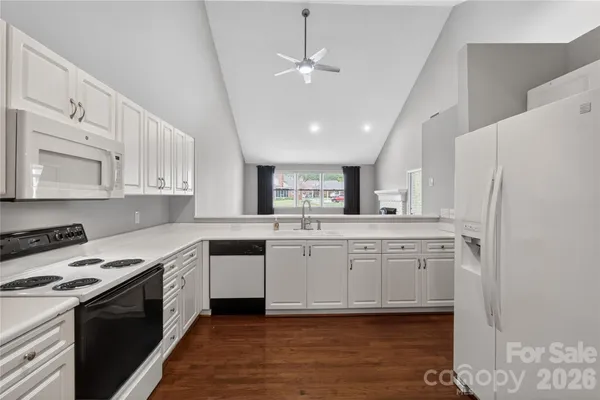 a kitchen with white cabinets and white appliances