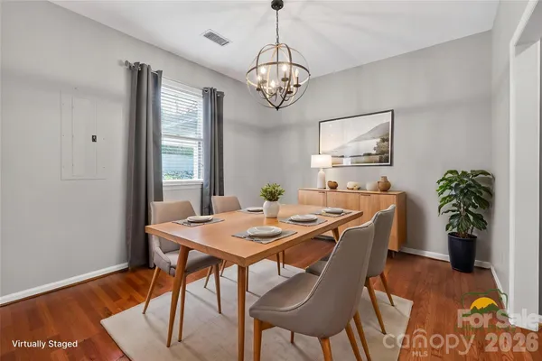 a dining room with furniture potted plants and wooden floor