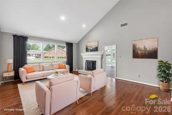 a living room with fireplace furniture and a large window