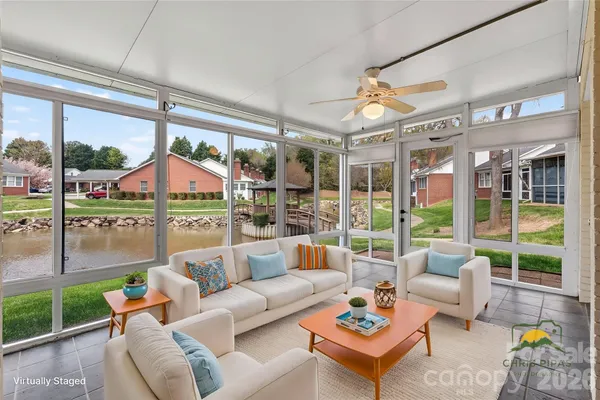 a living room with patio furniture and a potted plants