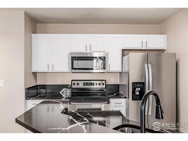 a kitchen with stainless steel appliances a stove a sink a refrigerator and cabinets