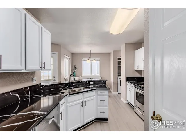 a kitchen with granite countertop a stove and a sink