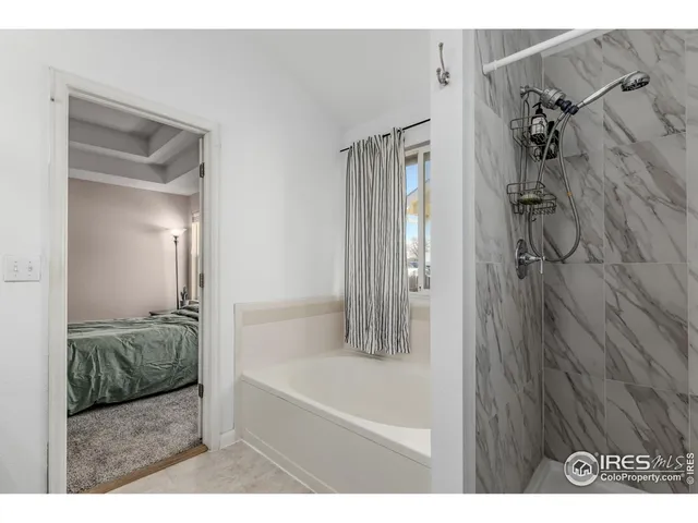 a en suite bathroom with a granite countertop tub shower and a sink