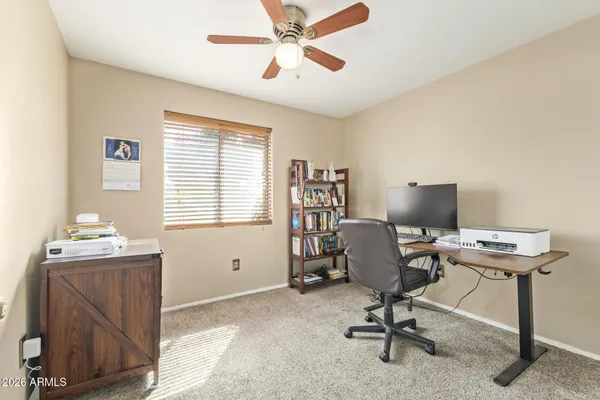 a view of a workspace with furniture and a window