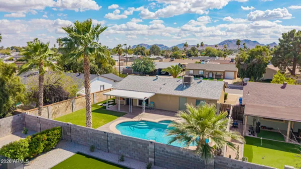 an aerial view of a house with swimming pool and lake view