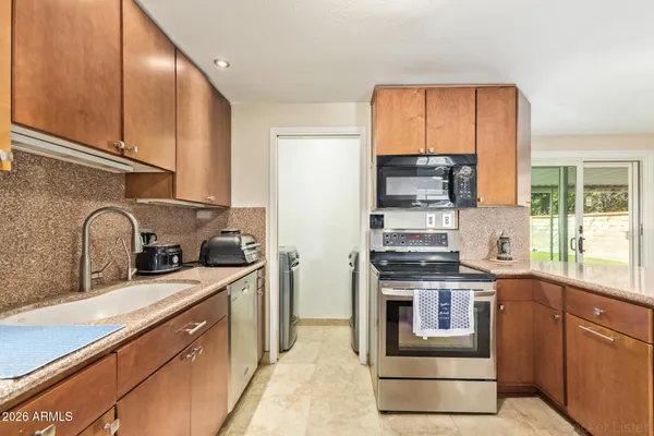 a kitchen with stainless steel appliances granite countertop a stove a sink dishwasher and a refrigerator