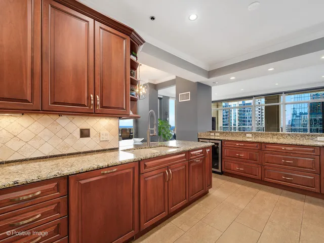 a kitchen with granite countertop wooden cabinets stainless steel appliances a sink and a window