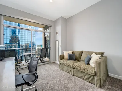 a living room with furniture a floor to ceiling window and floor to ceiling window