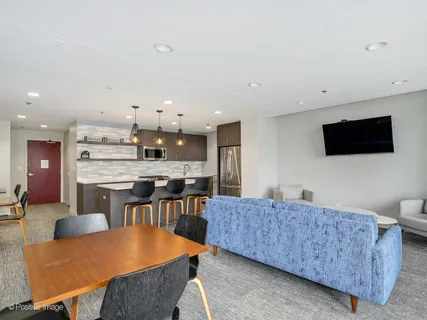 a living room with furniture a flat screen tv and kitchen view