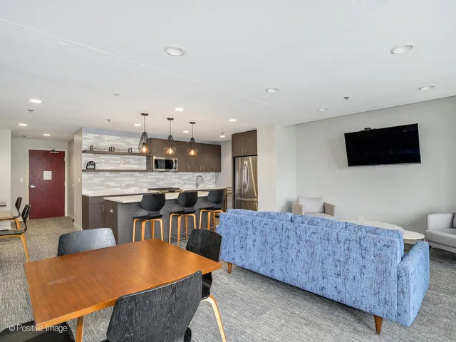 a living room with furniture a flat screen tv and kitchen view