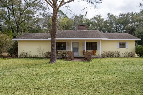 a view of a house with a yard and sitting area