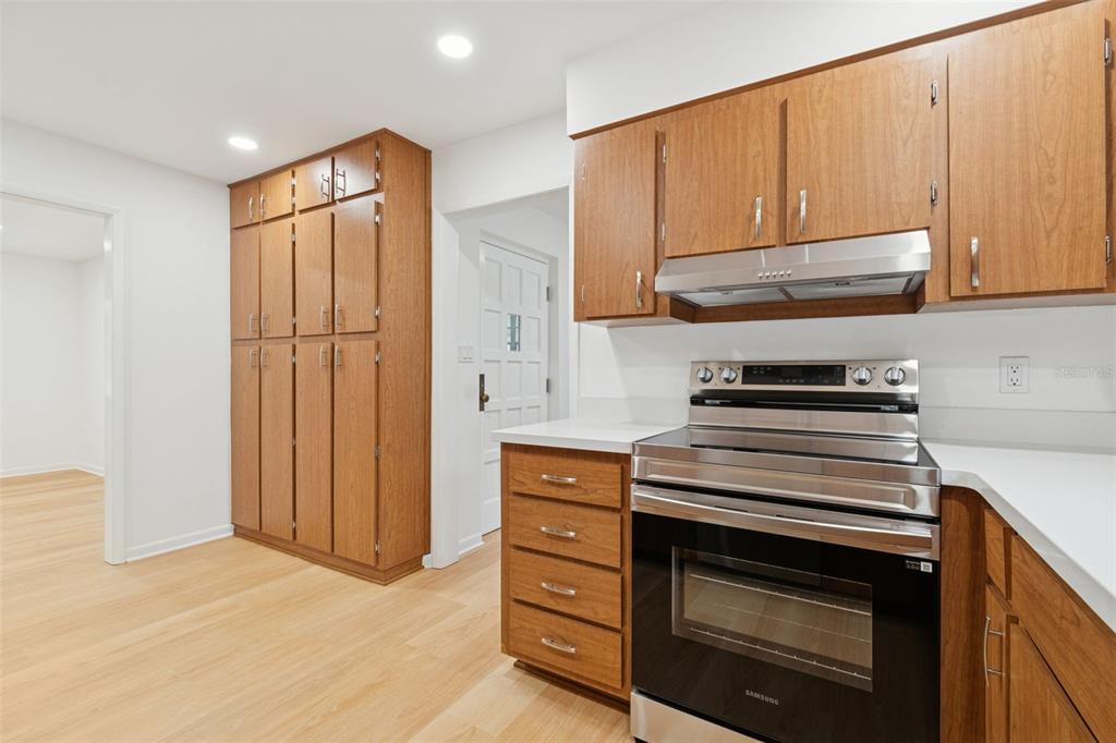 7011 Southwest 170th Street Archer, FL 32618 - Photo 11 of 35 a kitchen with stainless steel appliances wooden cabinets and a stove top oven