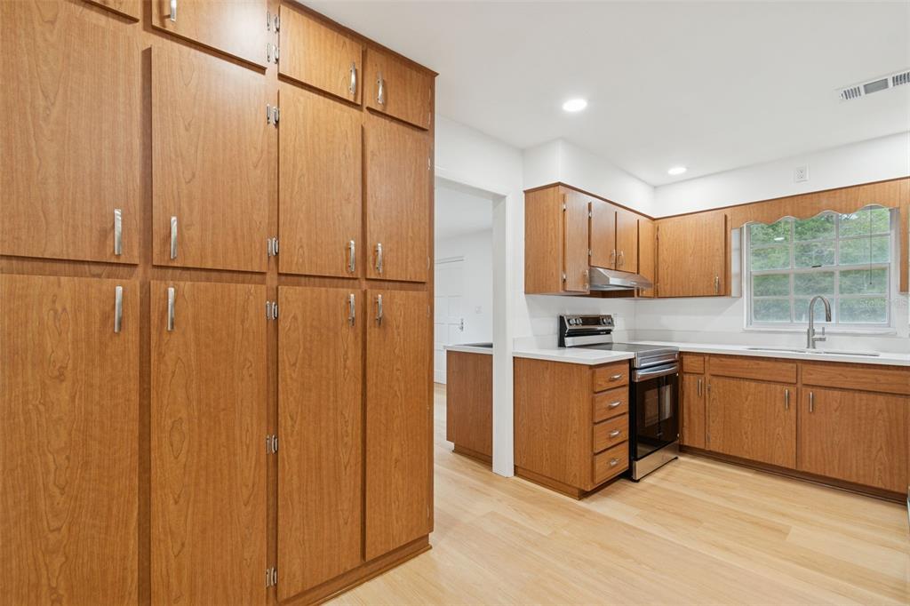 7011 Southwest 170th Street Archer, FL 32618 - Photo 13 of 35 a kitchen with stainless steel appliances granite countertop a refrigerator a sink a stove and wooden cabinets