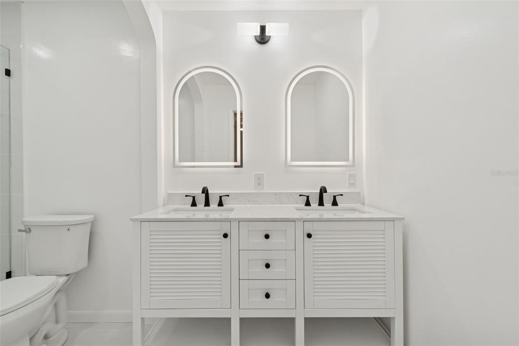 7011 Southwest 170th Street Archer, FL 32618 - Photo 18 of 35 a bathroom with a double vanity sink mirror and toilet