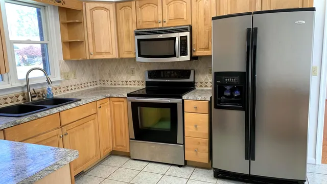 a kitchen with stainless steel appliances granite countertop a refrigerator stove and sink