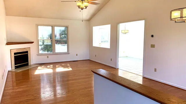 a view of empty room with wooden floor and fireplace