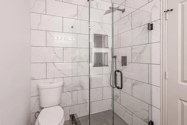 a bathroom with a toilet and a shower