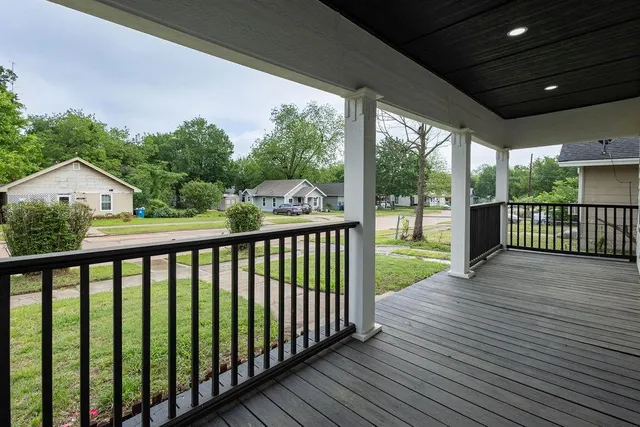 a view of a deck with wooden floor and fence next to a yard
