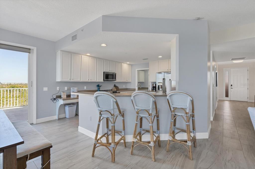 13113 Gasparilla Road, Unit 503 Placida, FL 33946 - Photo 4 of 18 a kitchen with stainless steel appliances granite countertop a dining table chairs stove a refrigerator and cabinets