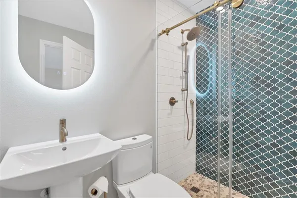a bathroom with a sink toilet and shower