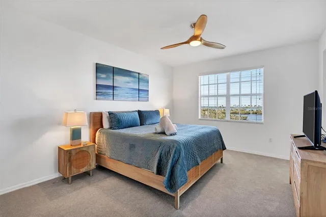 a bedroom with a bed flat screen tv and window