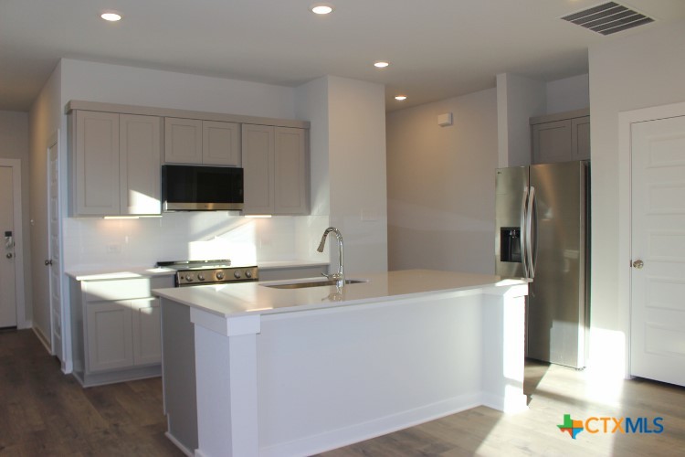 220 Escape Way Jarrell, TX 76537 - Photo 2 of 14 a kitchen with stainless steel appliances granite countertop a sink and a refrigerator