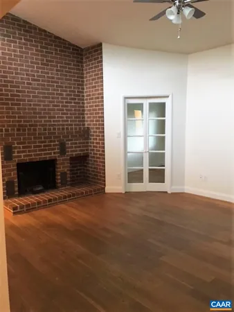 a view of an empty room with a fireplace and a window