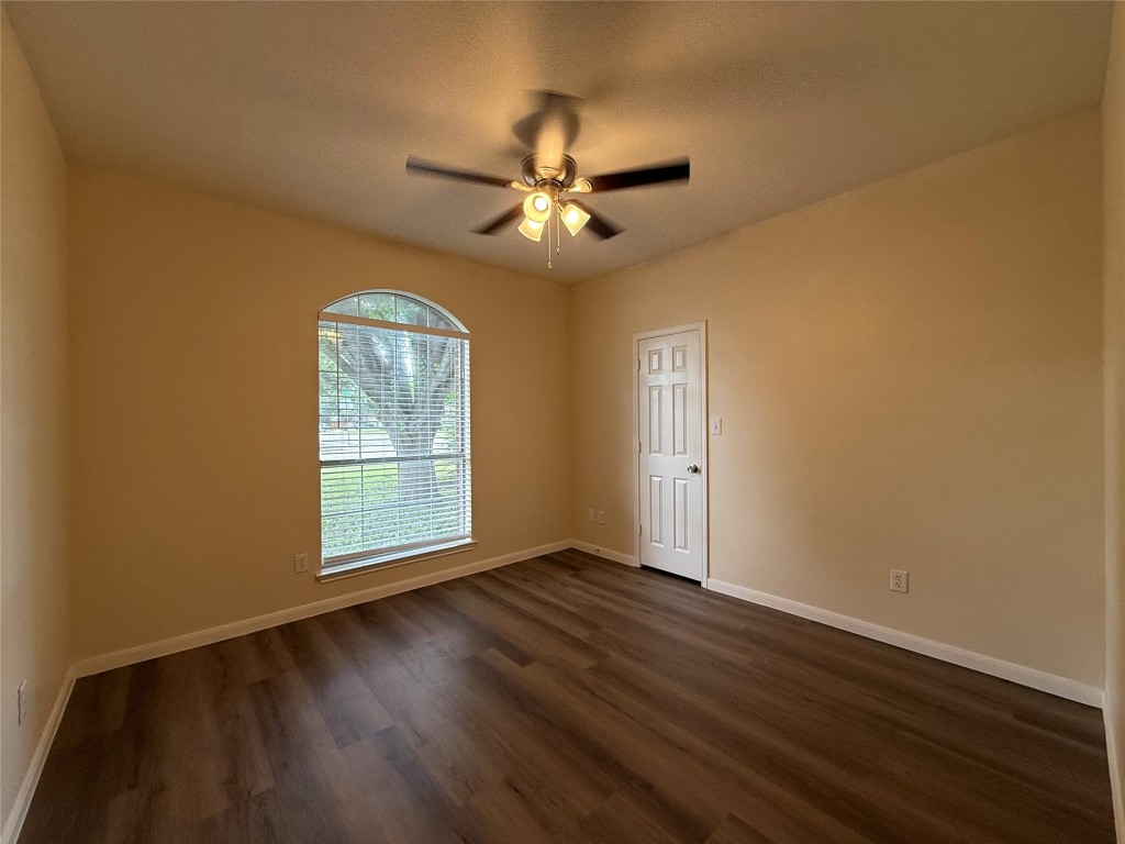 303 Kates Way Hutto, TX 78634 - Photo 12 of 15 an empty room with wooden floor fan and windows